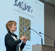 Ute A. Kaiser at the speakers desk in front of her presentation explaining Charges under the microscope